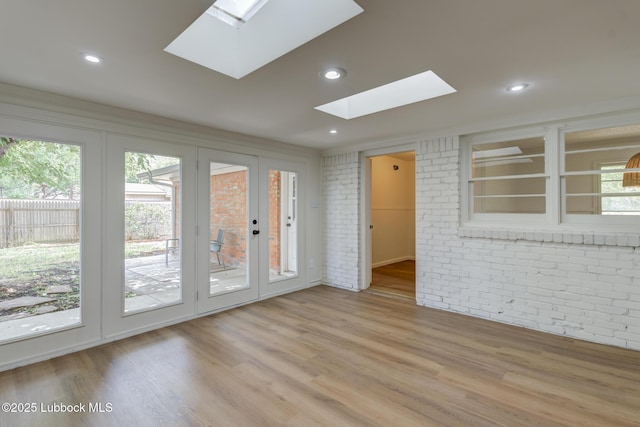 4013 48th St, Lubbock, TX 79413 - unfurnished room featuring a skylight, brick wall, wood finished floors, and recessed lighting