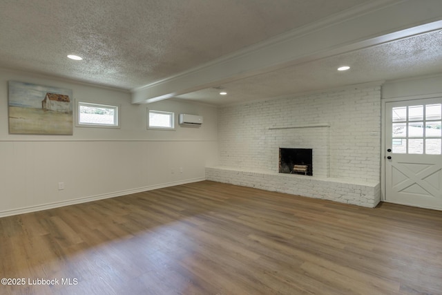 4013 48th St, Lubbock, TX 79413 - unfurnished living room featuring an AC wall unit, a textured ceiling, wood finished floors, a fireplace, and ornamental molding