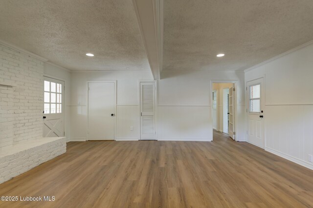 4013 48th St, Lubbock, TX 79413 - empty room with a textured ceiling, wood finished floors, healthy amount of natural light, crown molding, and brick wall
