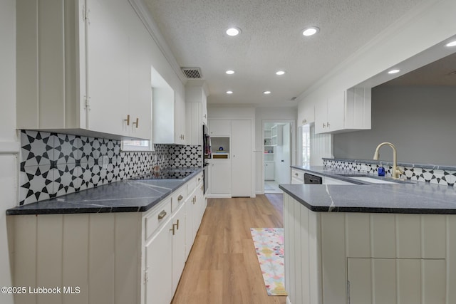 4013 48th St, Lubbock, TX 79413 - kitchen with a textured ceiling, recessed lighting, light wood-style flooring, backsplash, and white cabinetry