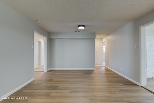 4013 48th St, Lubbock, TX 79413 - unfurnished room featuring a textured ceiling, light wood finished floors, and a smoke detector