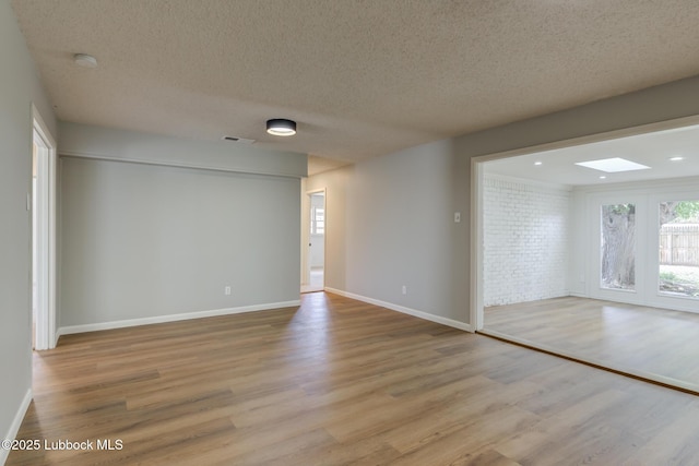 4013 48th St, Lubbock, TX 79413 - unfurnished room with a skylight, wood finished floors, a textured ceiling, and a smoke detector