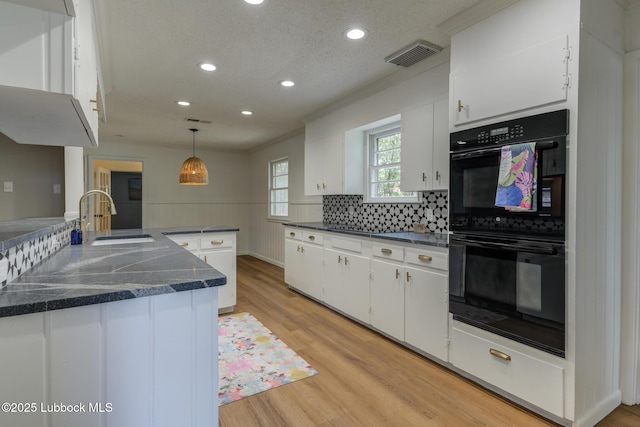 4013 48th St, Lubbock, TX 79413 - kitchen featuring dark countertops, recessed lighting, white cabinets, decorative backsplash, and light wood-type flooring