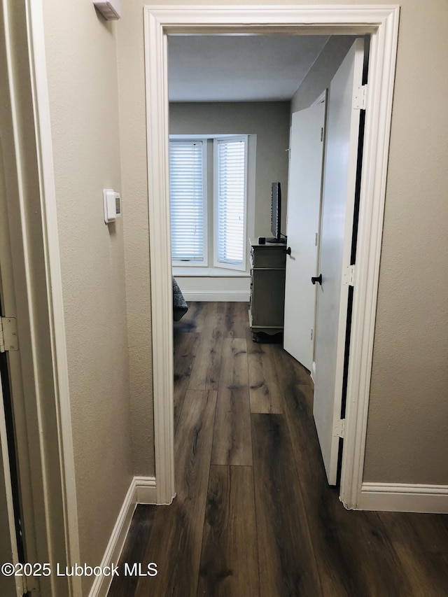 5712 73rd St, Lubbock, TX 79424 - hallway featuring dark wood-style floors and baseboards