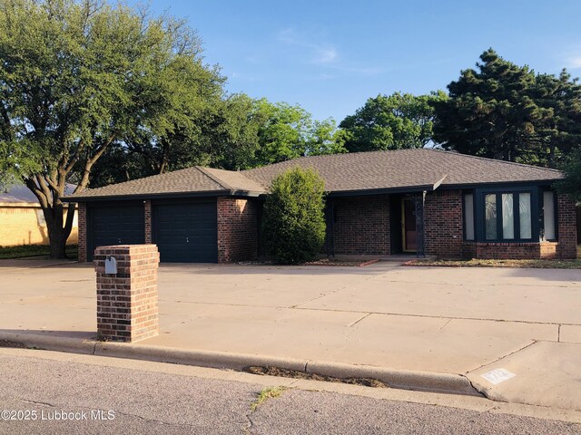 5712 73rd St, Lubbock, TX 79424 - view of front of home with concrete driveway, an attached garage, brick siding, and roof with shingles