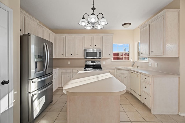 kitchen with sink, hanging light fixtures, stainless steel appliances, a center island, and light tile patterned flooring