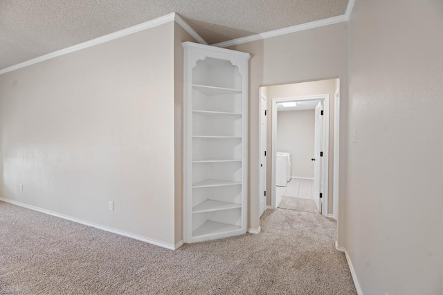 hallway featuring light carpet, washer / clothes dryer, ornamental molding, and a textured ceiling