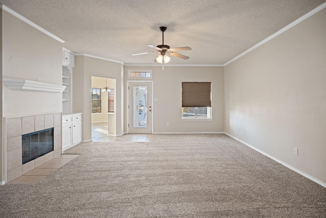 unfurnished living room featuring crown molding, a textured ceiling, ceiling fan, light colored carpet, and a fireplace