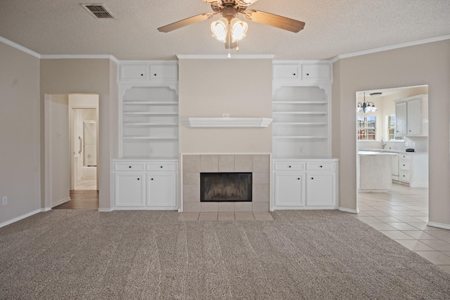 unfurnished living room with light carpet, ornamental molding, a fireplace, and visible vents