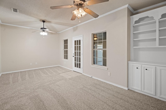 empty room with light carpet, ceiling fan, crown molding, and a textured ceiling