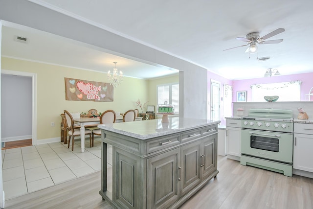 3123 22nd St, Lubbock, TX 79410 - kitchen with visible vents, crown molding, light wood-style floors, high end range, and ceiling fan with notable chandelier