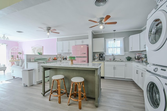 3123 22nd St, Lubbock, TX 79410 - kitchen featuring a ceiling fan, visible vents, stacked washer / drying machine, a sink, and freestanding refrigerator