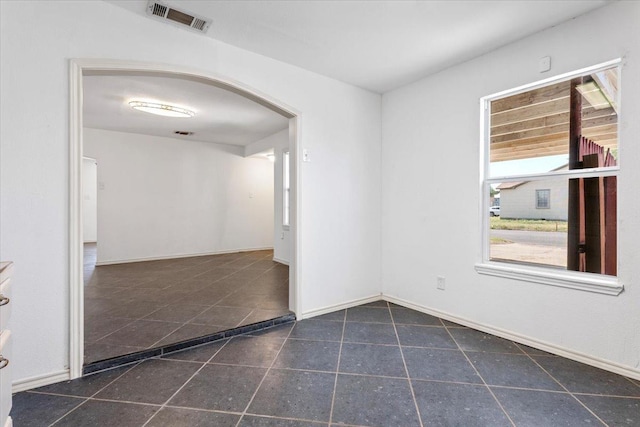 spare room with dark tile patterned flooring