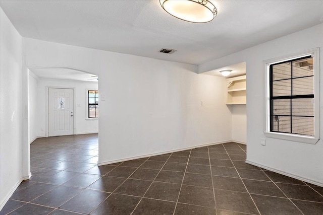 empty room featuring dark tile patterned flooring