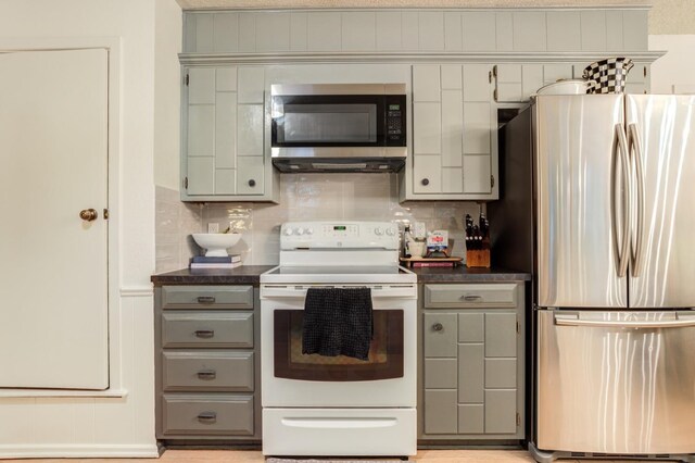 kitchen with tasteful backsplash, appliances with stainless steel finishes, and gray cabinets