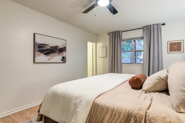 bedroom with ceiling fan, a textured ceiling, and light wood-type flooring