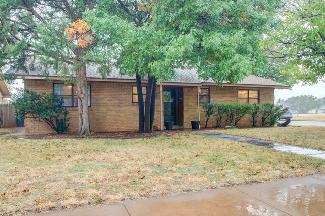 single story home featuring a front lawn