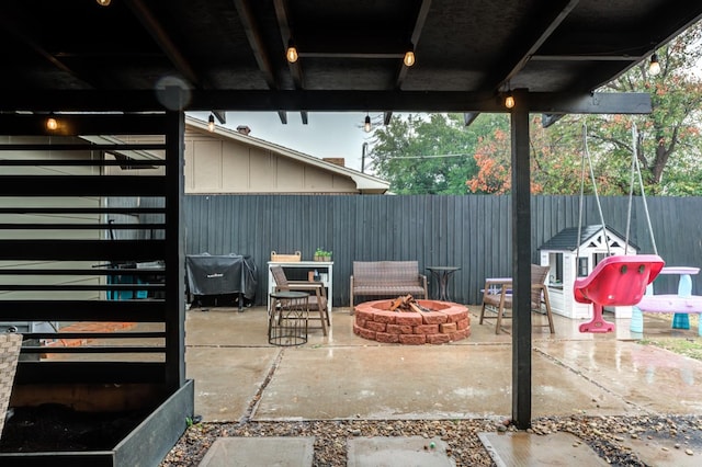 view of patio featuring an outbuilding and a fire pit