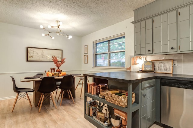 kitchen with light wood-type flooring, a chandelier, decorative backsplash, stainless steel dishwasher, and a textured ceiling