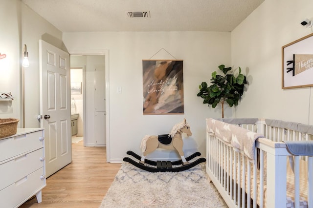 bedroom with light hardwood / wood-style flooring and a textured ceiling