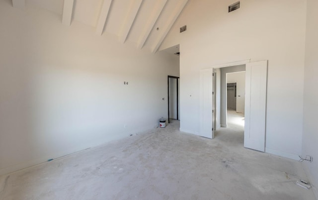 spare room with beamed ceiling and high vaulted ceiling