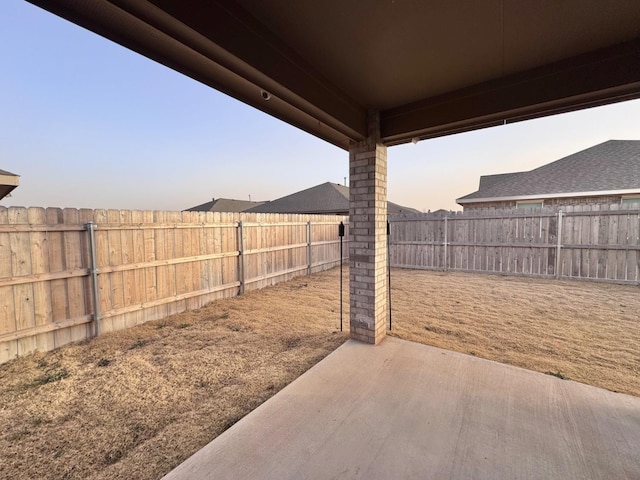 yard at dusk featuring a patio area