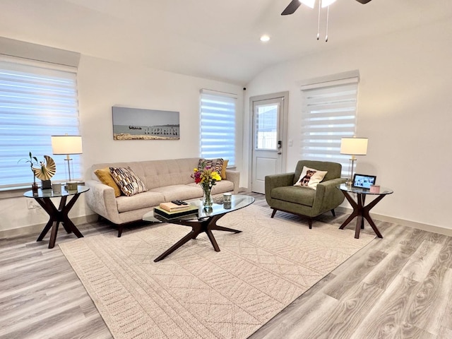 living room featuring ceiling fan, lofted ceiling, and light hardwood / wood-style floors