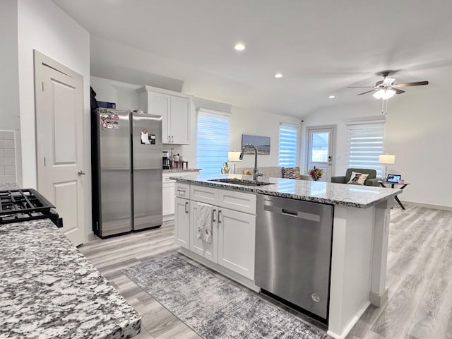 kitchen featuring stainless steel appliances, sink, a center island with sink, and white cabinets