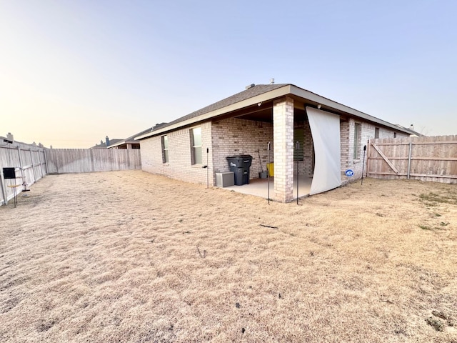 back house at dusk with cooling unit and a patio area