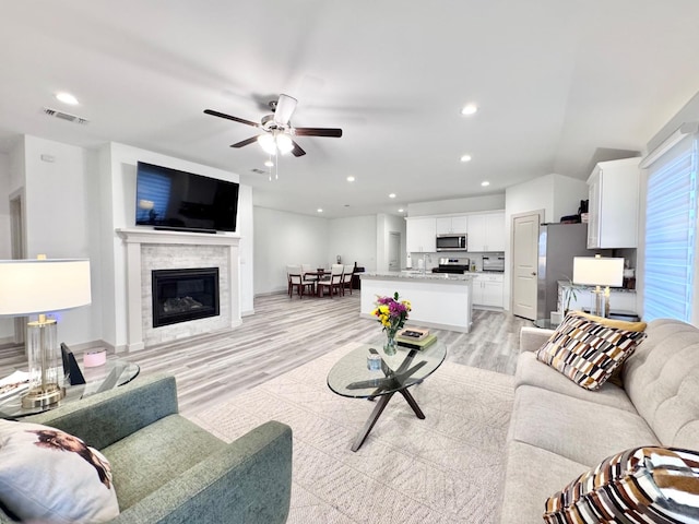 living room with ceiling fan and light hardwood / wood-style floors