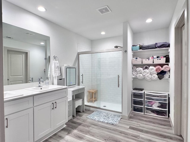 bathroom with a shower with door, vanity, and hardwood / wood-style flooring