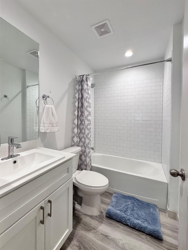 full bathroom featuring hardwood / wood-style flooring, vanity, toilet, and shower / bath combo