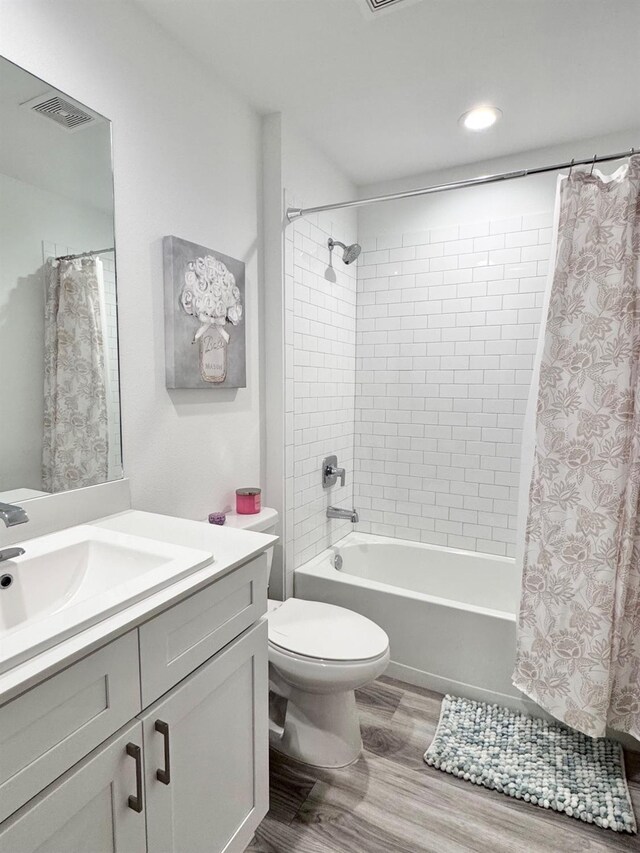 full bathroom with shower / tub combo, vanity, toilet, and hardwood / wood-style floors