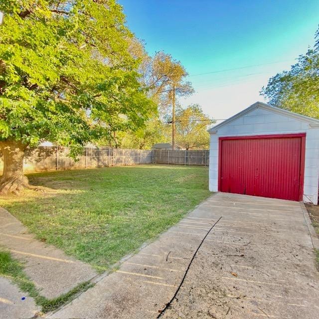 view of yard featuring a garage and an outdoor structure