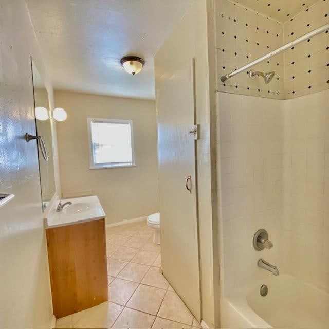 full bathroom featuring tiled shower / bath combo, vanity, tile patterned flooring, and toilet