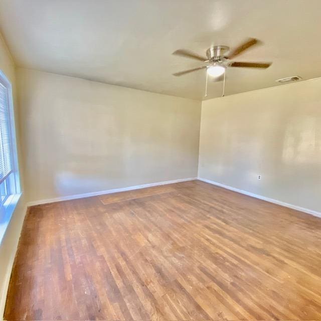 empty room with ceiling fan and light hardwood / wood-style floors