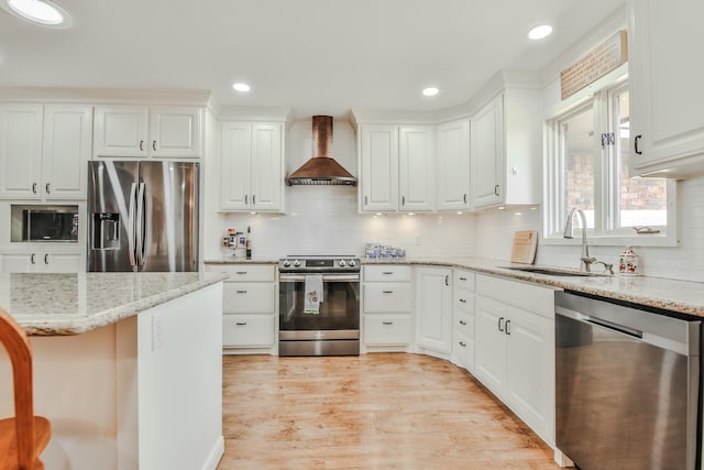 kitchen with wall chimney exhaust hood, a sink, appliances with stainless steel finishes, and tasteful backsplash