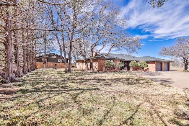 view of front of home with a garage, brick siding, and concrete driveway