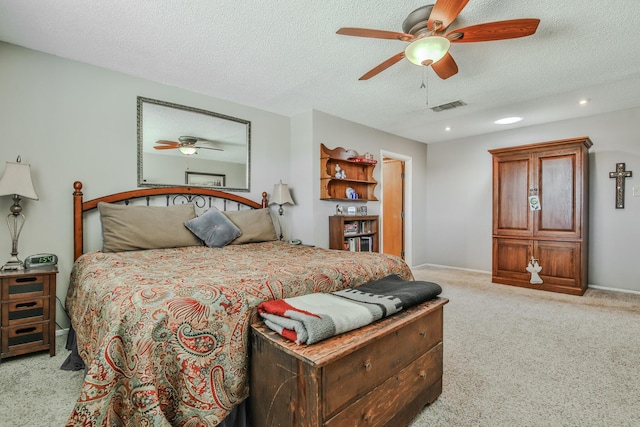 bedroom featuring visible vents, a ceiling fan, a textured ceiling, and carpet