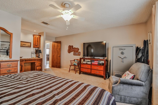 bedroom with a textured ceiling, visible vents, ceiling fan, and light carpet