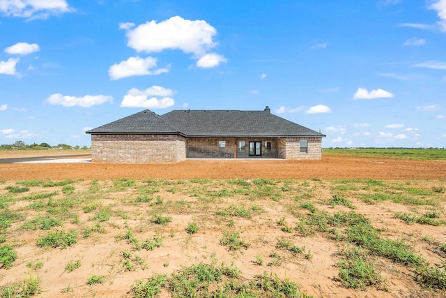 back of house with a rural view