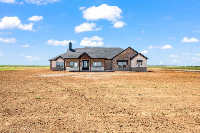 view of front facade featuring a front yard and a rural view