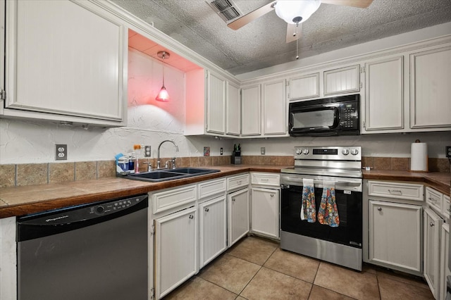 kitchen featuring sink, a textured ceiling, pendant lighting, stainless steel appliances, and white cabinets