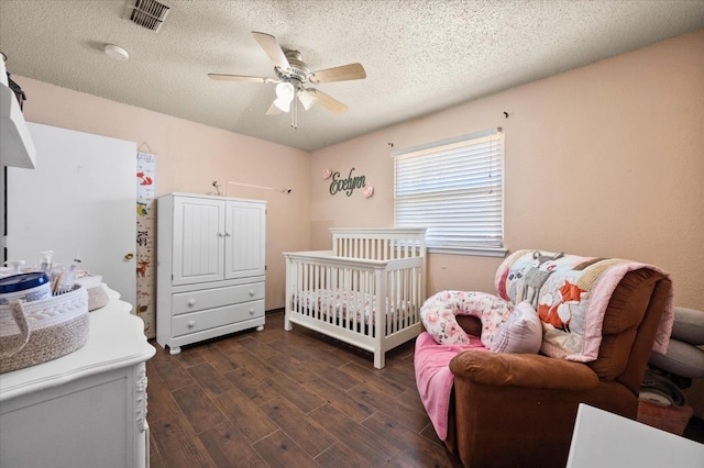 bedroom with ceiling fan, dark hardwood / wood-style floors, and a textured ceiling