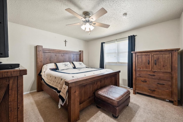 carpeted bedroom with ceiling fan and a textured ceiling