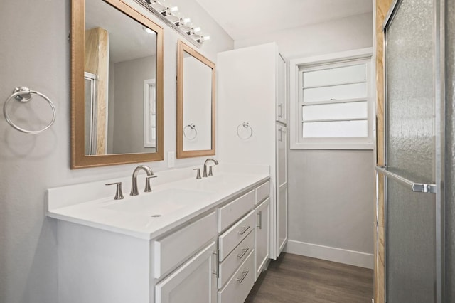 5217 45th St, Lubbock, TX 79414 - bathroom featuring wood finished floors, double vanity, and baseboards