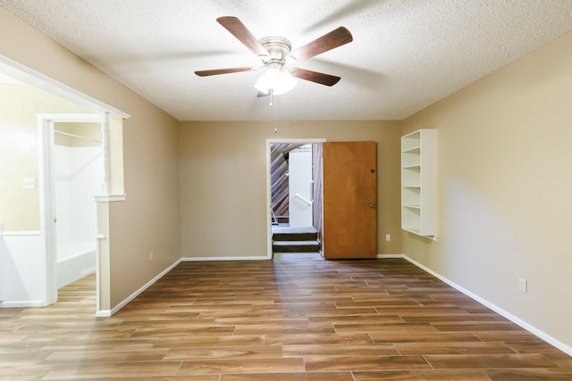 empty room featuring hardwood / wood-style floors, a textured ceiling, and ceiling fan