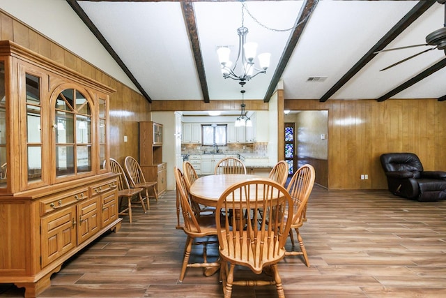 dining space with lofted ceiling with beams, light hardwood / wood-style floors, and wood walls