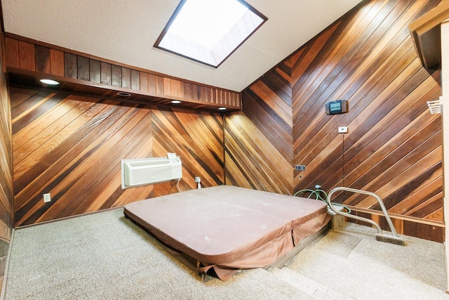 interior space with a skylight, carpet, a wall mounted air conditioner, and wood walls