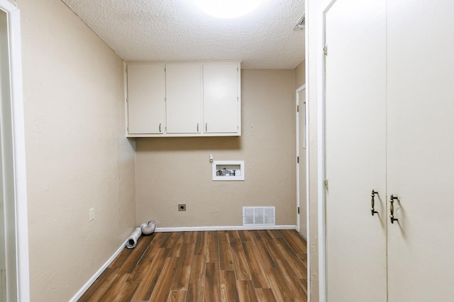 clothes washing area with dark hardwood / wood-style flooring, cabinets, hookup for a washing machine, electric dryer hookup, and a textured ceiling